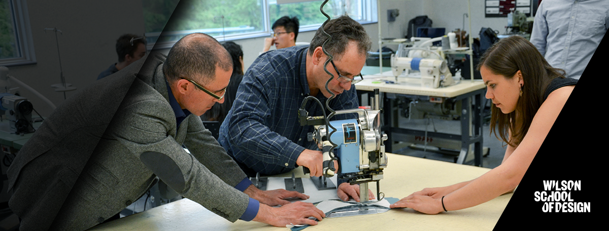 Teachers working together to cut some fabric.
